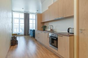 uma cozinha com armários de madeira e uma grande janela em Tamula Lake View Apartment em Võru