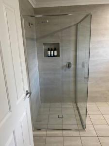 a shower with a glass door in a bathroom at Ranges Over the Bay in Culburra Beach