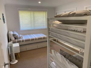 a bedroom with two bunk beds and a window at Ranges Over the Bay in Culburra Beach