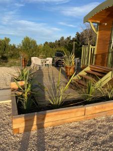 a wooden deck with plants in front of a house at LA ROULOTTE DE MOUCHOU in Saintes-Maries-de-la-Mer