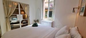 un osito de peluche sentado en una cama blanca en una habitación en Appartement Vieux Nice, en Niza