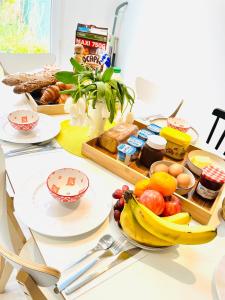 a table with a tray of food and fruit on it at Private rooms in a Tiny home 4 min drive to Airport CDG ,1 private bathroom ideal for families and friends in Roissy-en-France