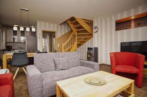 a living room with a couch and a table at idyllisches Ferienhaus mit eigener Sauna, Kamin und Terrasse - Haus Kranich in Vieregge