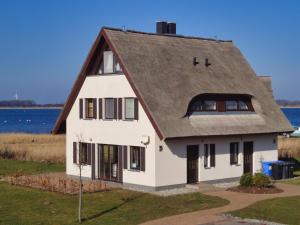 a white house with a brown roof at idyllisches Ferienhaus mit eigener Sauna, Kamin und Terrasse - Haus Kranich in Vieregge