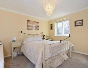 - une chambre avec un lit et un lustre dans l'établissement Home From Home - your peaceful haven close to Goodwood and Chichester, à Lavant