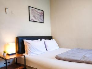 1 dormitorio con 1 cama y mesa auxiliar en Sleep House 2BR Wifi Unlimited, en Cirebon