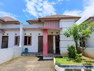a white house with a red door at Sleep House 2BR Wifi Unlimited in Cirebon