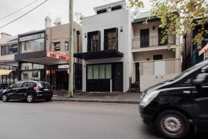 two cars parked on a street in front of buildings at The Sarah by Urban Rest in Sydney