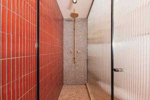 baño con pared roja y puerta en The Sarah by Urban Rest en Sídney