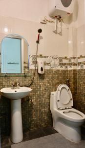 uma casa de banho com um WC, um lavatório e um espelho. em Cao Bang Eco Homestay em Cao Bang