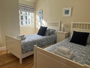 Eaglesham的住宿－South Craighall B&B，一间卧室设有两张床和窗户。