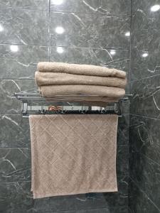 einen Haufen Handtücher auf einem Handtuchhalter im Bad in der Unterkunft Двухкомнатная квартира in Promyshlennyy