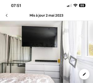 Pokój z telewizorem, łóżkiem i oknem w obiekcie Chambre cosy w mieście Vaulx-en-Velin