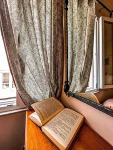 two books sitting on a table next to a window at Central 9 Rooms in Ermoupoli