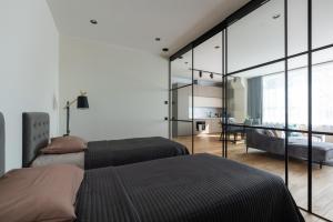 Cet appartement comprend une chambre avec deux lits et un salon. dans l'établissement Sauna Apartment Tamula, à Võru