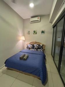 Schlafzimmer mit einem Bett mit blauer Bettwäsche und Kissen in der Unterkunft Entire Unit Pacific 63/JayaonePJ/Wifi/Pool/Balcony in Petaling Jaya