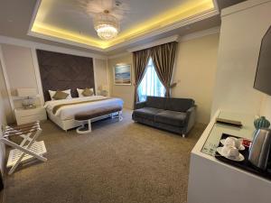 Habitación de hotel con cama y sofá en Remaj Hotel, en Taif