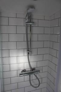 a shower in a bathroom with white tile walls at Waterbeach Boatel in Cambridge