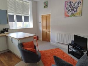 a living room with a counter and a chair and a table at No. 1 Orange St in Uppingham