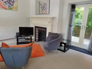 a living room with a couch and a chair and a fireplace at No. 1 Orange St in Uppingham