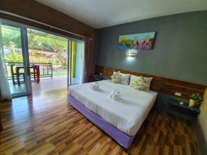 a bedroom with a bed and a sliding glass door at Greenery Resort Koh Tao in Ko Tao