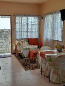 Sala de estar con 2 camas y 2 mesas en Haira Traveller's Home, en Iligan