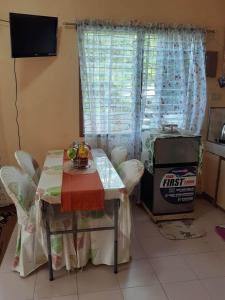 una mesa y sillas en una cocina con ventana en Haira Traveller's Home, en Iligan