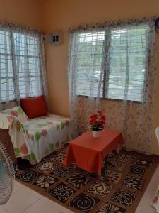 - une chambre avec un lit, une table et des fenêtres dans l'établissement Haira Traveller's Home, à Iligan