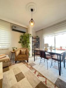 een woonkamer met een eettafel en stoelen bij Şehrin kalbindeki deniz manzaralı 3+1 ev in Mersin