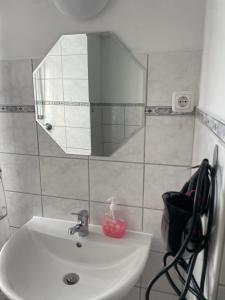 ein Bad mit einem Waschbecken und einem Spiegel in der Unterkunft Ferienwohnung Nähe Hbf Bremerhaven in Bremerhaven