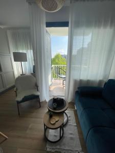 a living room with a blue couch and a balcony at Comodo apartman Vinkovci in Vinkovci