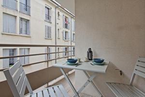 a table and chairs on a balcony with a window at L'Ecluse - Clim - Parking - Central in Nîmes