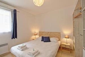 a bedroom with a bed with two towels on it at L'Ecluse - Clim - Parking - Central in Nîmes