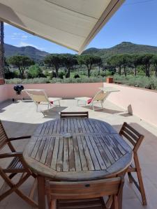 Une table et des chaises en bois sont disponibles sur la terrasse. dans l'établissement RESIDENCE TERME ISOLA D'ELBA SRL, à Portoferraio