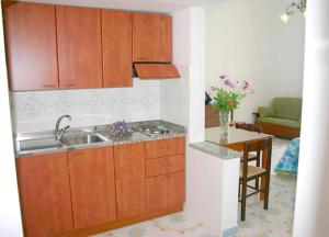 a kitchen with wooden cabinets and a sink and a table at Ludovica Apartment Type B in Positano