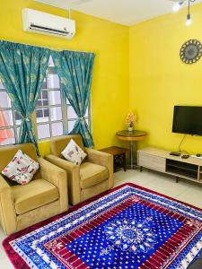 a living room with two chairs and a rug at Homestay Zalida C Musleem in Kampong Alor Gajah