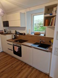 a kitchen with a stove and a sink and a window at Beethoven29 / Studio mit Garten direkt in Krems in Krems an der Donau