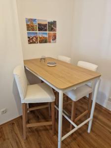 mesa de comedor con sillas blancas y mesa de madera en Beethoven29 / Studio mit Garten direkt in Krems en Krems an der Donau