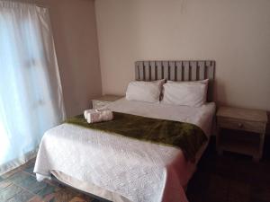 a bedroom with a large bed with white sheets and a window at Insolam Accommodation in Mokopane