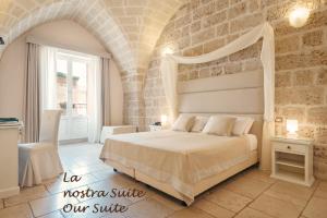 Un dormitorio con una cama y una pared de piedra. en Hotel L'Arcangelo - Boutique Hotel, en Taranto
