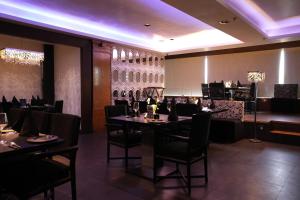 une salle à manger avec des tables et des chaises ainsi qu'un bar dans l'établissement Hotel Hardeo, à Nagpur