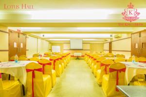 een kamer met tafels en stoelen met gele en rode bogen bij Kings Hotel Egmore in Chennai