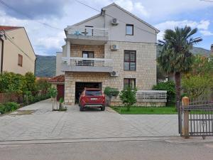 a red car parked in front of a house at Apartmani Amira Trebinje in Trebinje