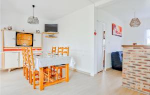 cocina y comedor con mesa y sillas en Nice Home In Creances-plage With 2 Bedrooms And Wifi, en Créances