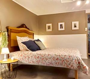 ein Schlafzimmer mit einem Bett und einem Tisch mit einer Lampe in der Unterkunft Le Grenier, Climatisation Terrasse Wi-Fi Netflix 15 mn coeur de ville in Béziers
