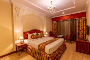 une chambre d'hôtel avec un lit et un lustre dans l'établissement Hotel Hardeo, à Nagpur