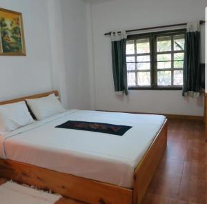 1 dormitorio con 1 cama grande y ventana en The Hillside Residence, en Muang Phônsavan