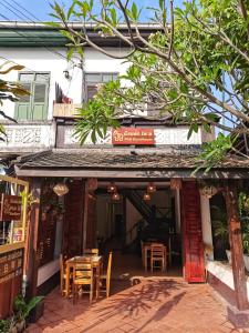 ein Restaurant mit Tischen und Stühlen vor einem Gebäude in der Unterkunft PHAI GUESTHOUSE in Luang Prabang