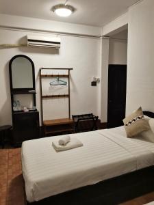 ein Schlafzimmer mit einem Bett und einem Handtuch darauf in der Unterkunft PHAI GUESTHOUSE in Luang Prabang