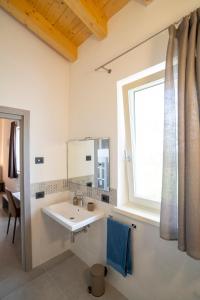 La salle de bains est pourvue d'un lavabo et d'une fenêtre. dans l'établissement RipassoQui, à Custoza